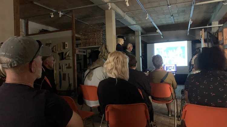 Menschen in einem dunklen Raum schauen sich eine Power-Point-Präsentation an
